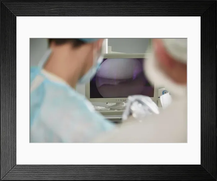 Framed Print : Male doctor looking at monitoring equipment in operating room Framed Print : Male doctor looking at monitoring equipment in operating room