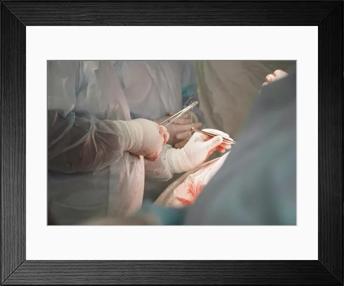 Framed Print : Midsection of medical team performing surgery in operating room