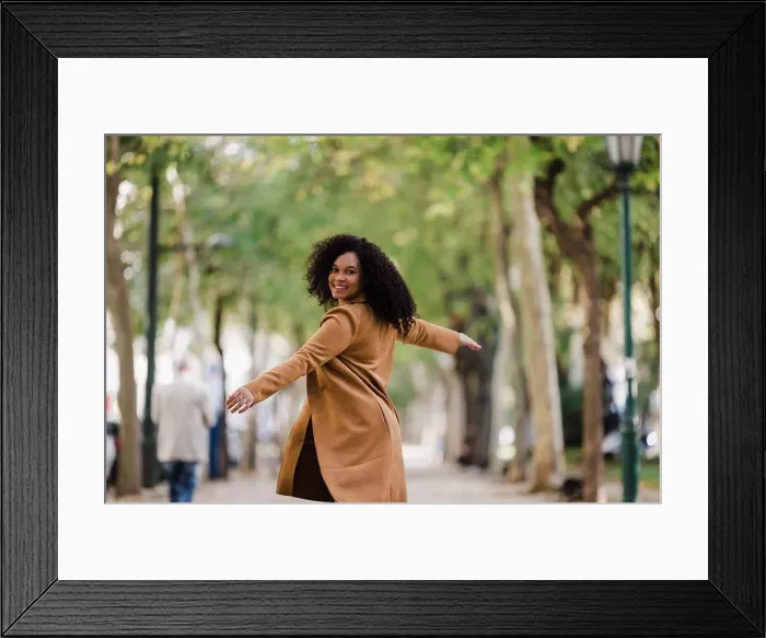 Framed Print : Portrait carefree young woman dancing on treelined sidewalk Framed Print : Portrait carefree young woman dancing on treelined sidewalk