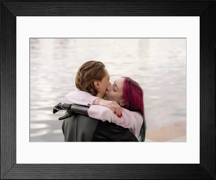 Framed Print : Woman with amputated hand kissing boyfriend on cheek by river Framed Print : Woman with amputated hand kissing boyfriend on cheek by river