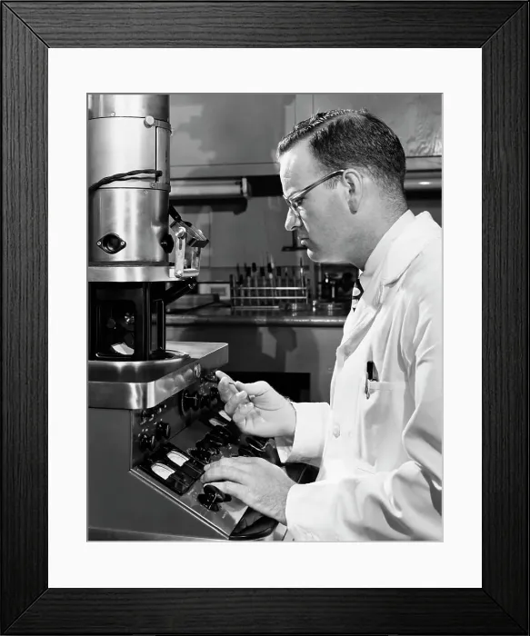 Framed Print : Side profile of a scientist working on an electron microscope Framed Print : Side profile of a scientist working on an electron microscope