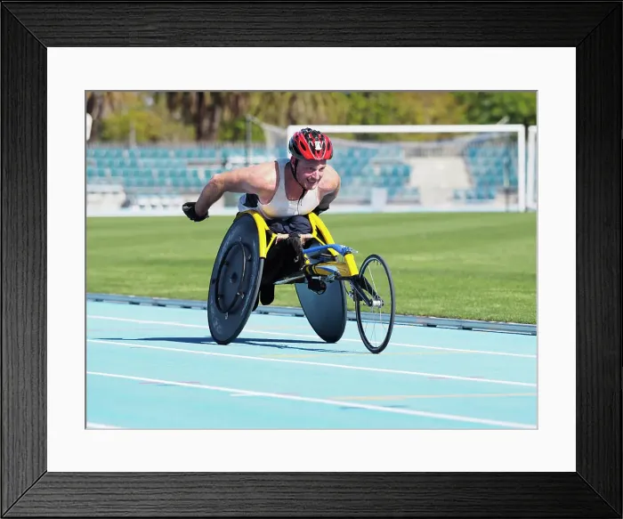 Framed Print : Man racing in wheelchair on track