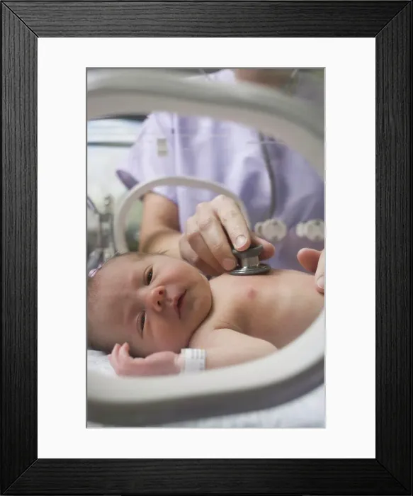 Framed Print : Doctor examining a newborn baby boy Framed Print : Doctor examining a newborn baby boy