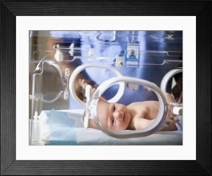 Framed Print : Baby in incubator with man in uniform Framed Print : Baby in incubator with man in uniform