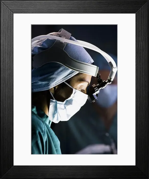 Framed Print : Female doctor in scrubs with head light in surgery