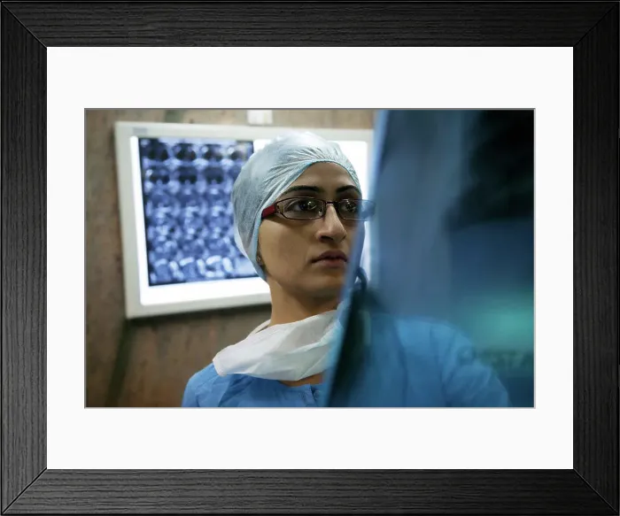 Framed Print : Surgeon looking at an X-ray chart Framed Print : Surgeon looking at an X-ray chart