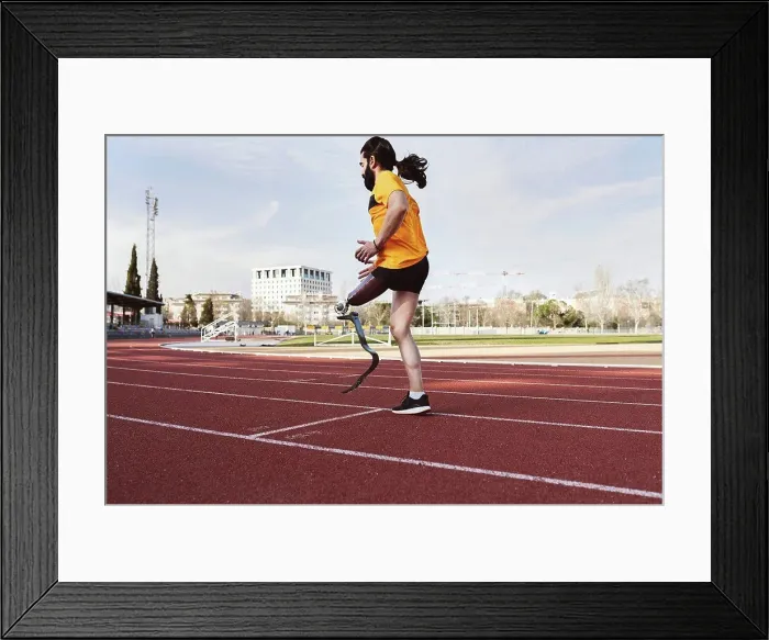 Framed Print : Athlete with prosthetic leg warming up on running track Framed Print : Athlete with prosthetic leg warming up on running track