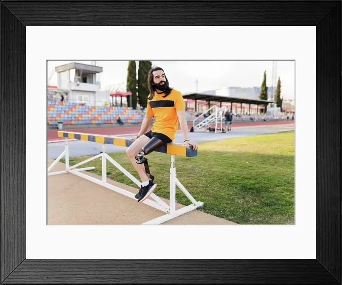 Framed Print : Man with prosthetic leg sitting on hurdle Framed Print : Man with prosthetic leg sitting on hurdle
