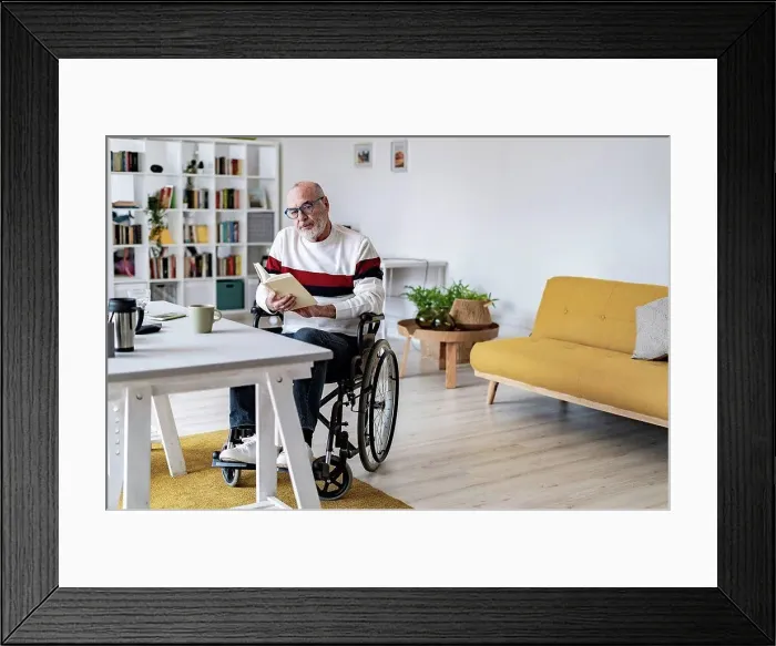 Framed Print : Serious disabled man holding diary at home office