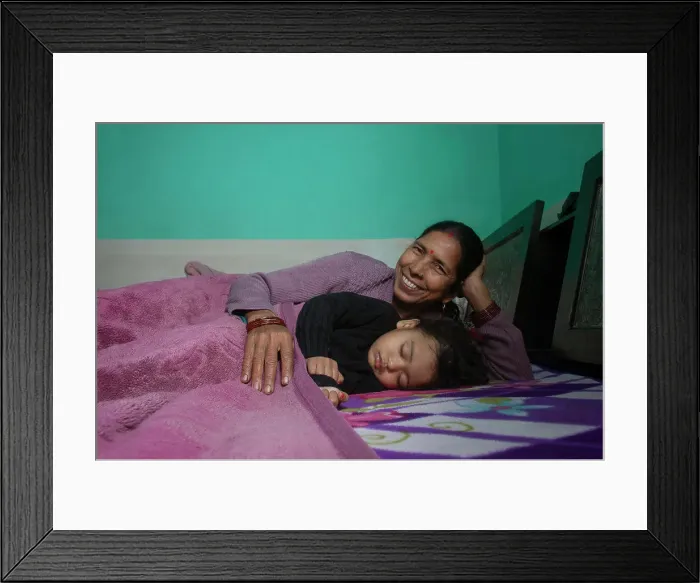 Framed Print : Grandmother and her little granddaughter sleeping together in bed. India Framed Print : Grandmother and her little granddaughter sleeping together in bed. India