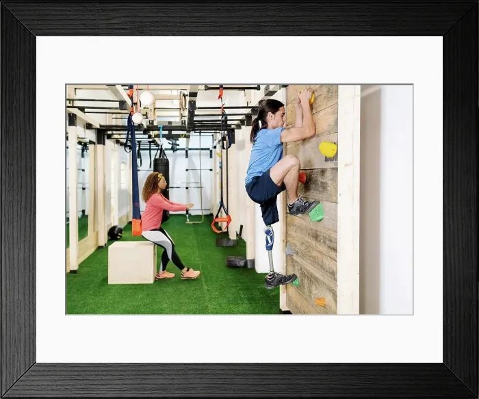 Framed Print : Disabled sportsman climbing wall in gym Framed Print : Disabled sportsman climbing wall in gym