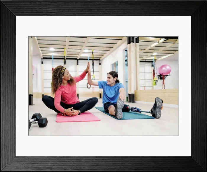 Framed Print : Smiling disabled athlete giving high-five to friend in gym