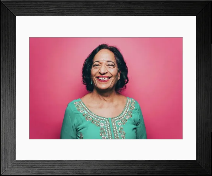 Framed Print : Portrait of smiling senior woman wearing salwar kameez against pink background Framed Print : Portrait of smiling senior woman wearing salwar kameez against pink background