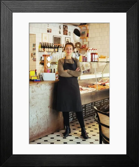 Framed Print : Portrait of confident young female owner standing with arms crossed at cafe Framed Print : Portrait of confident young female owner standing with arms crossed at cafe