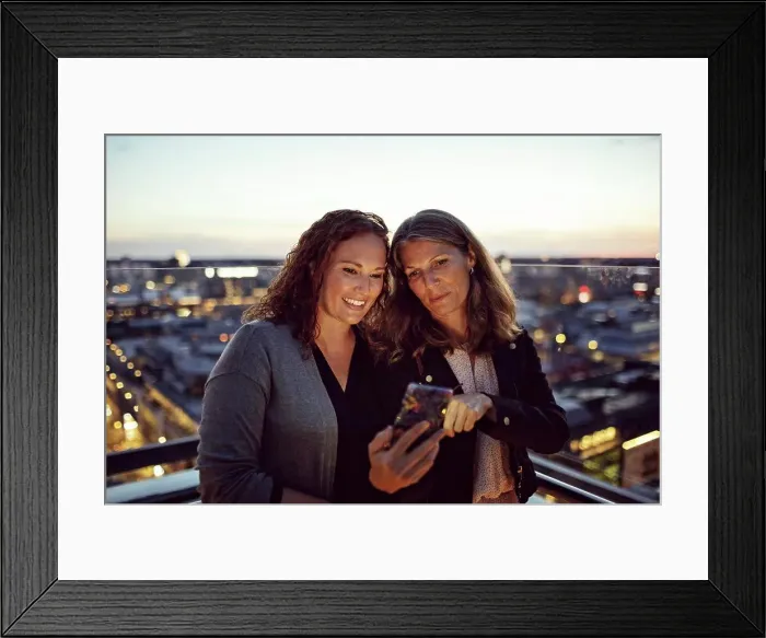 Framed Print : Businesswomen taking selfie on smart phone while standing on terrace after work Framed Print : Businesswomen taking selfie on smart phone while standing on terrace after work