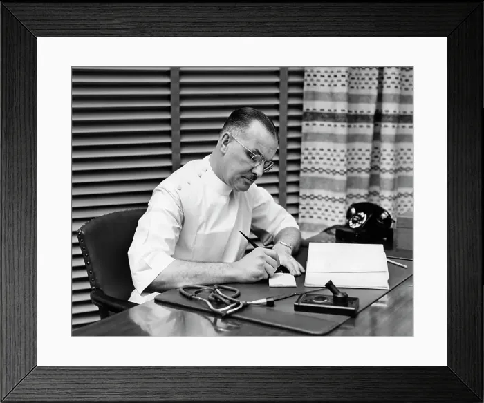 Framed Print : 1940S Doctor Sitting At Desk Writing Prescription Framed Print : 1940S Doctor Sitting At Desk Writing Prescription