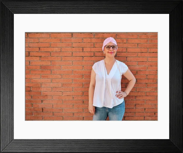 Framed Print : Mature woman with hand on hip standing in front of brick wall Framed Print : Mature woman with hand on hip standing in front of brick wall