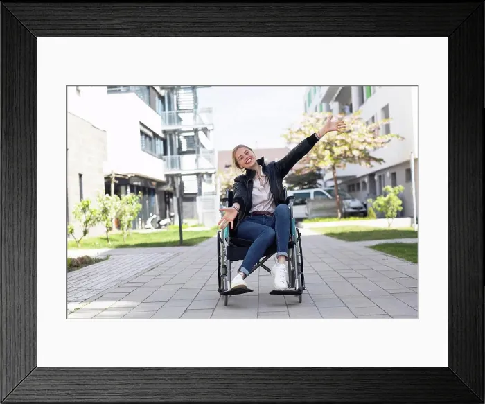 Framed Print : Happy disabled woman with arms outstretched sitting on wheelchair in residential area Framed Print : Happy disabled woman with arms outstretched sitting on wheelchair in residential area