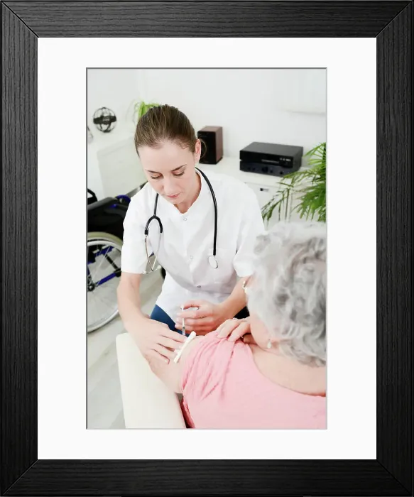 Framed Print : Cheerful young woman doctor giving vaccine injection to elderly woman at home Framed Print : Cheerful young woman doctor giving vaccine injection to elderly woman at home