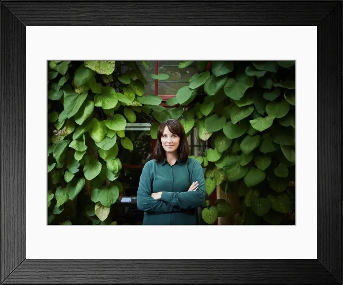 Framed Print : Portrait of confident female architect standing against creeper plants in backyard Framed Print : Portrait of confident female architect standing against creeper plants in backyard