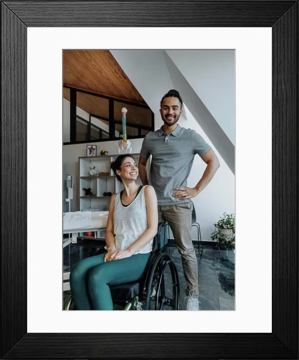 Framed Print : Smiling male physiotherapist standing while female patient sitting on wheelchair Framed Print : Smiling male physiotherapist standing while female patient sitting on wheelchair