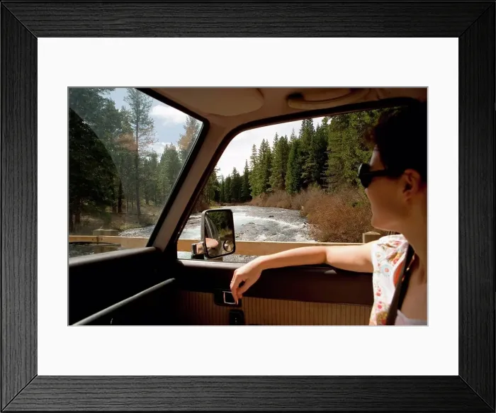 Framed Print : Woman looking through car window at forest scenery Framed Print : Woman looking through car window at forest scenery