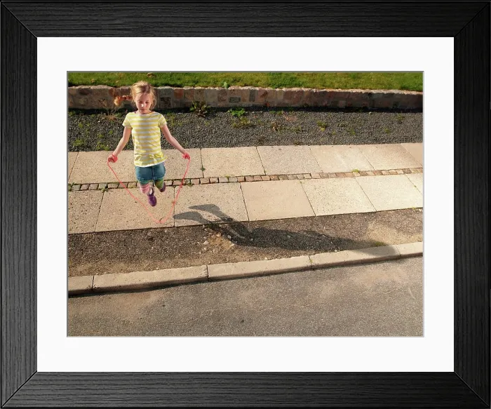 Framed Print : Young girl skipping on sidewalk Framed Print : Young girl skipping on sidewalk