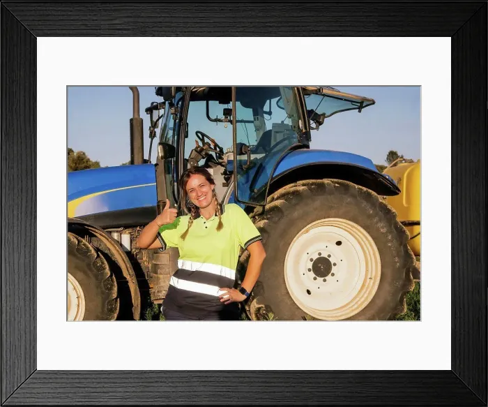Framed Print : Happy female farmer gesturing thumbs up in front of tractor on sunny day