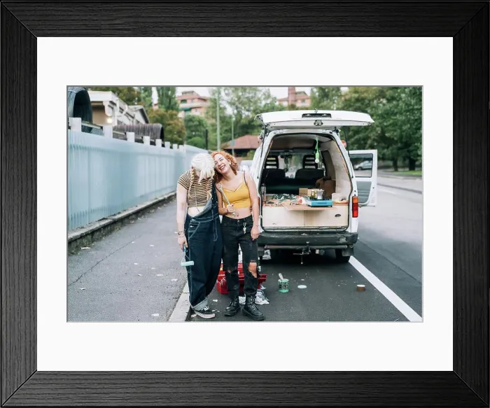 Framed Print : Happy female couple, standing near their van