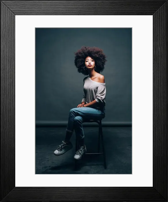 Framed Print : Portrait of a young woman sitting on stool Framed Print : Portrait of a young woman sitting on stool