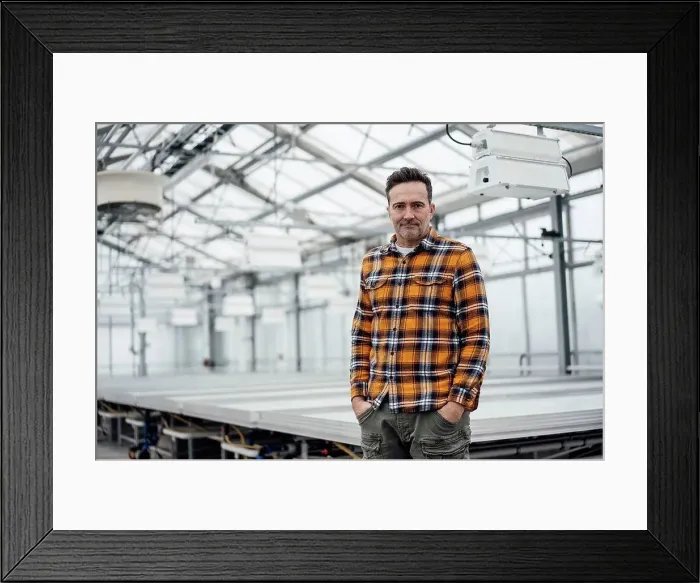 Framed Print : Businessman standing with hands in pockets at greenhouse Framed Print : Businessman standing with hands in pockets at greenhouse