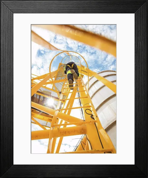 Framed Print : Worker climbing up ladder at tank Framed Print : Worker climbing up ladder at tank