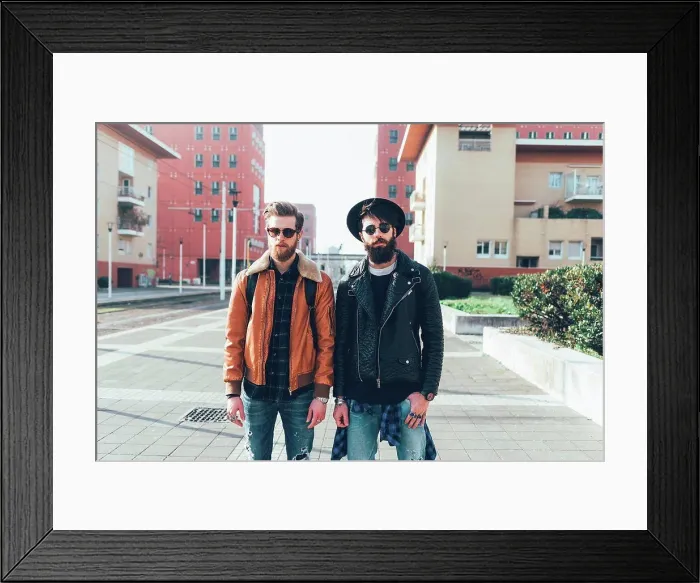 Framed Print : Portrait of two young male hipster friends standing in city housing estate Framed Print : Portrait of two young male hipster friends standing in city housing estate