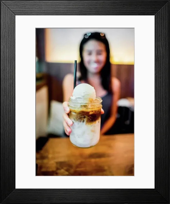Framed Print : Young woman holding coffee float at Farm to Table, Bangkok, Thailand Framed Print : Young woman holding coffee float at Farm to Table, Bangkok, Thailand