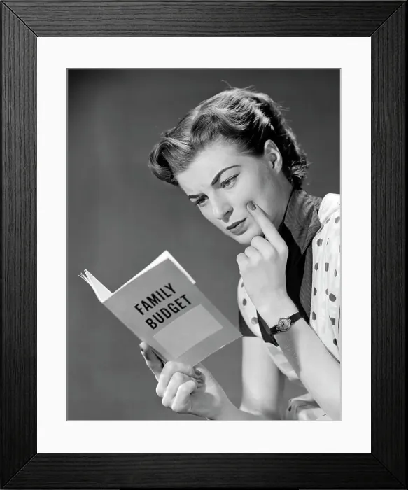 Framed Print : 1950S Woman In Apron Finger On Cheek Looking At Family Budget Book Framed Print : 1950S Woman In Apron Finger On Cheek Looking At Family Budget Book