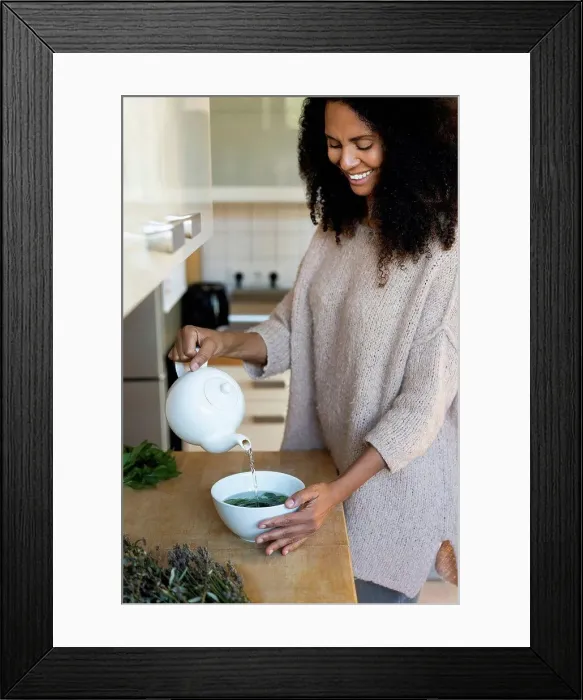 Framed Print : Happy woman pouring water in bowl while to prepare tea at home Framed Print : Happy woman pouring water in bowl while to prepare tea at home