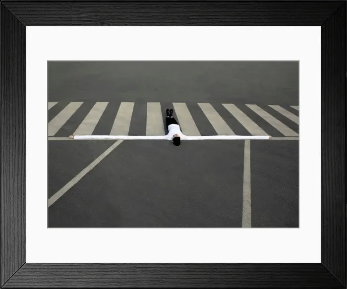 Framed Print : Woman with artificial long hands lying on zebra crossing Framed Print : Woman with artificial long hands lying on zebra crossing
