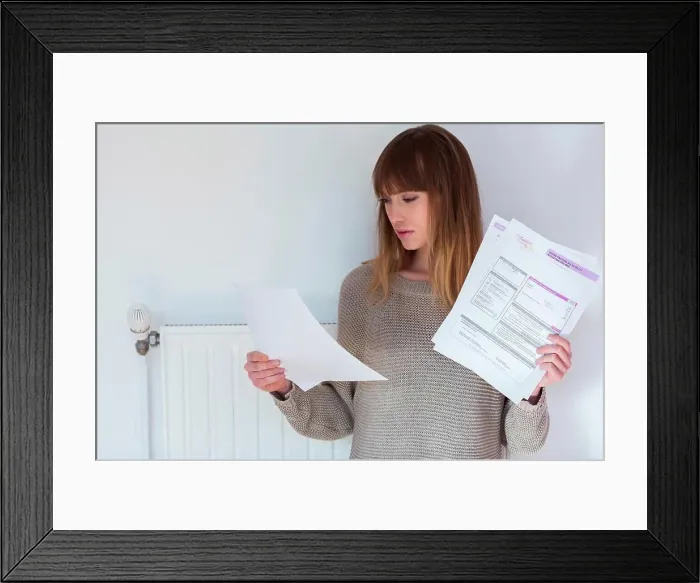 Framed Print : Woman checking her heat consumption Framed Print : Woman checking her heat consumption