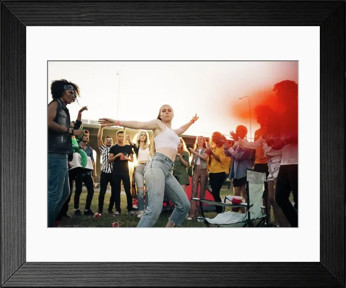 Framed Print : Young woman dancing while friends enjoying in musical event during summer Framed Print : Young woman dancing while friends enjoying in musical event during summer