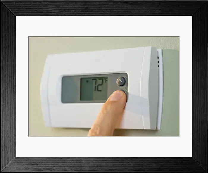 Framed Print : Man adjusting thermostat