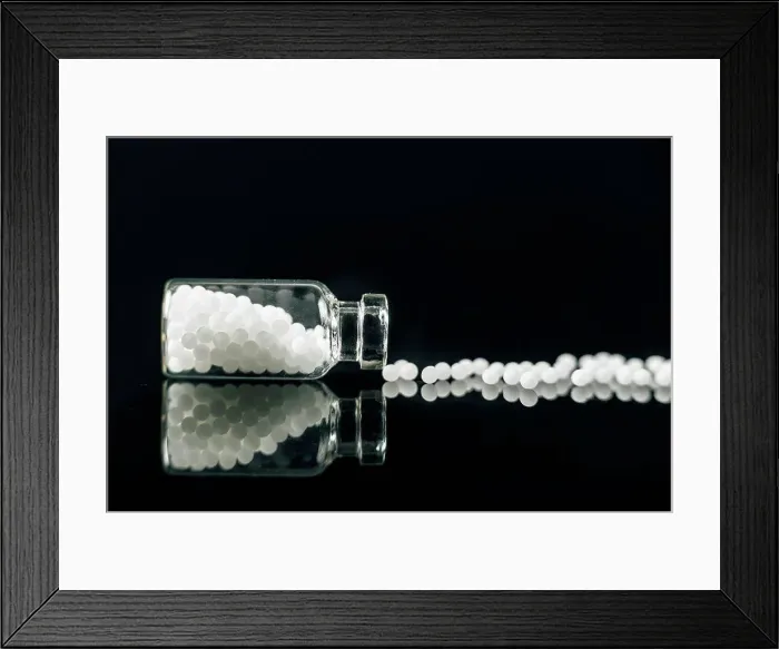 Framed Print : Homeopathic globules scattered out of glass bottle Framed Print : Homeopathic globules scattered out of glass bottle