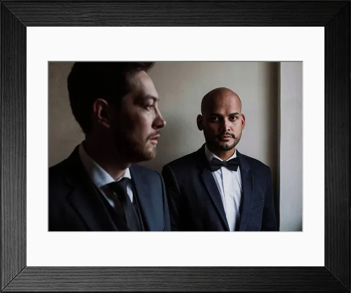 Framed Print : Gay couple in suits standing against wall on wedding day Framed Print : Gay couple in suits standing against wall on wedding day