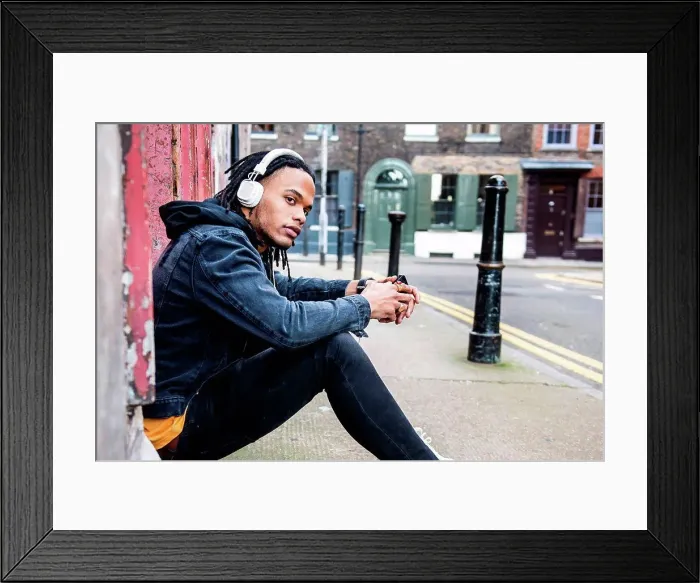 Framed Print : Man sitting in street listening to music through headphones Framed Print : Man sitting in street listening to music through headphones