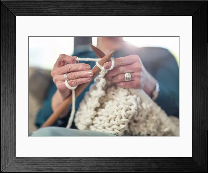 Framed Print : Senior woman knitting on couch at home