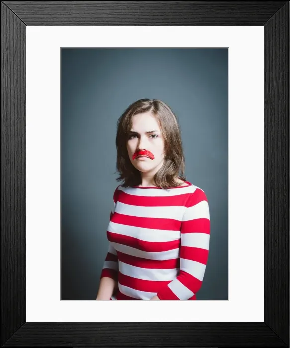 Framed Print : Young woman wearing mask against a grey background in studio