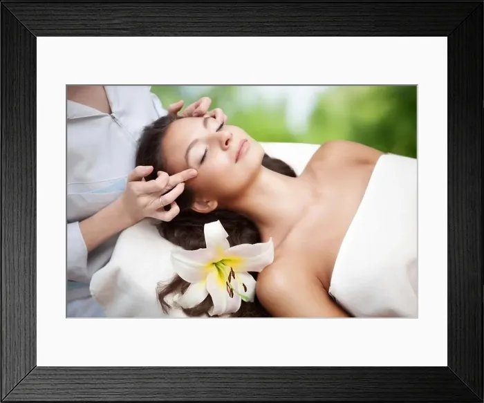 Framed Print : Young beautiful relaxing woman having a facial massage