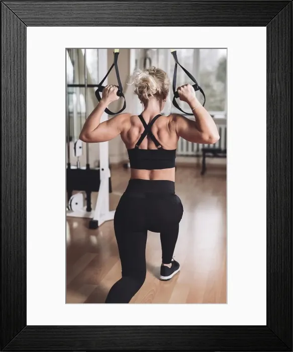 Framed Print : strong girl in the gym pumping her arms and back muscles on the exercise machine Framed Print : strong girl in the gym pumping her arms and back muscles on the exercise machine