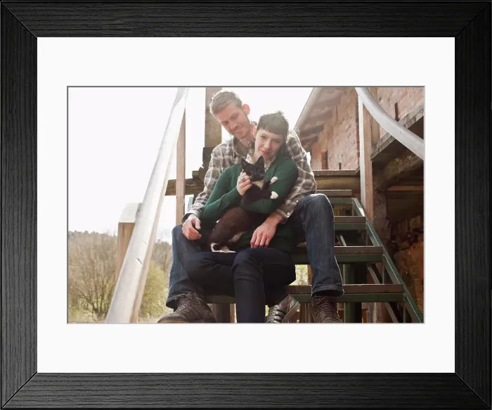 Framed Print : A couple holding and petting a cat Framed Print : A couple holding and petting a cat