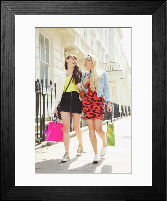 Framed Print : Happy young women friends walking arm in arm with shopping bags