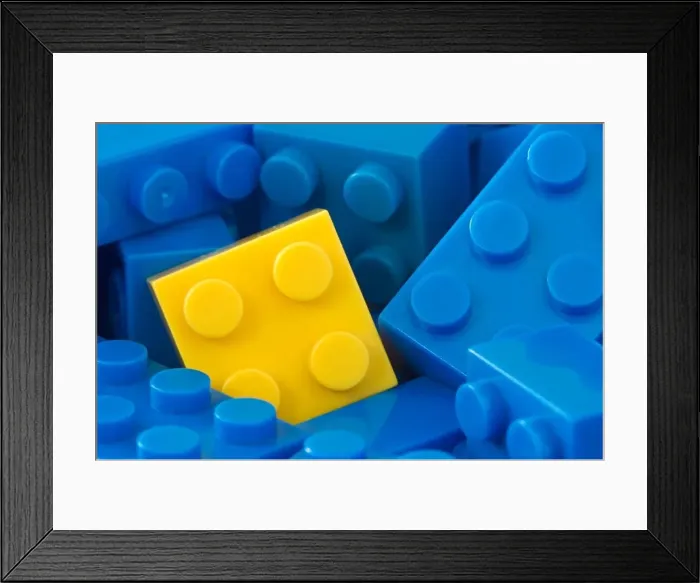 Framed Print : color toy background. yellow plastic brick in a middle of blue ones Framed Print : color toy background. yellow plastic brick in a middle of blue ones